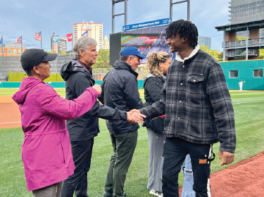 student shaking hands with adults